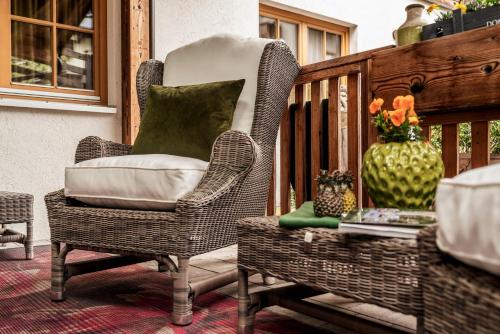 a wicker chair sitting on a porch with a vase at Mountainspirit in Mayrhofen