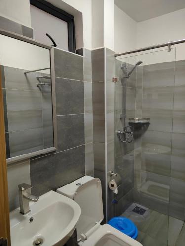 a bathroom with a toilet and a sink and a shower at Favorite staycation by Janice in Nairobi