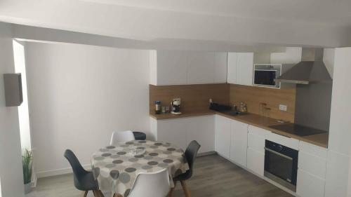 une cuisine avec une table et des chaises dans une pièce dans l'établissement Cœur de Ville Yffiniac, à Yffiniac