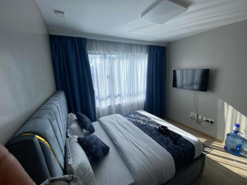 ein Schlafzimmer mit einem Bett und einem großen Fenster in der Unterkunft Favorite staycation by Janice in Nairobi