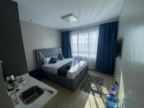 ein Schlafzimmer mit einem Bett mit einem Waschbecken und einem Fenster in der Unterkunft Favorite staycation by Janice in Nairobi