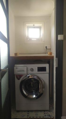 - un lave-linge et un sèche-linge dans une chambre avec fenêtre dans l'établissement Cœur de Ville Yffiniac, à Yffiniac