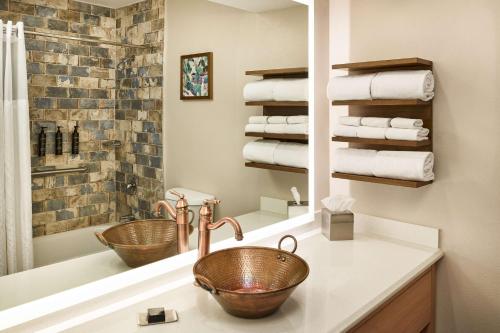 a bathroom with two sinks and a mirror and towels at Hilton Tapestry Collection, Hotel Don Fernando De Taos in Taos