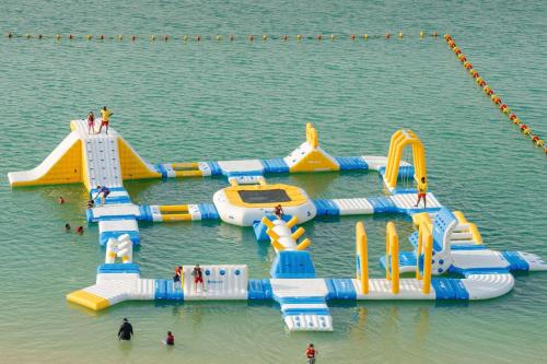 a water park with a water slide in the water at Marsa Malaz Kempinski, The Pearl in Doha