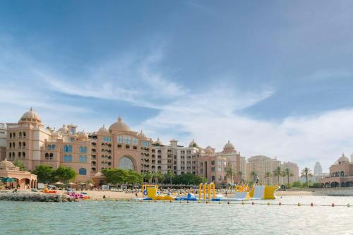 ein Strand vor einem großen Gebäude in der Unterkunft Marsa Malaz Kempinski, The Pearl in Doha