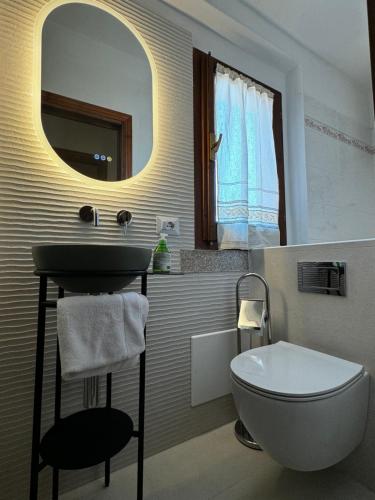 a bathroom with a sink and a toilet and a mirror at casa a pochi minuti dalla spiaggia di vignola in Vignola Mare