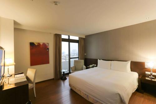 a hotel room with a bed and a large window at CHECK inn SELECT Hualien LinSen in Hualien City