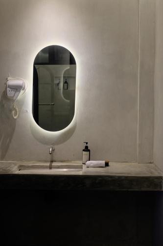 a bathroom sink with a mirror and a soap dispenser at Sora Boutique Stay in Ciwidey