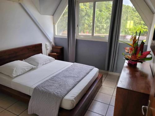 1 dormitorio con 1 cama y 2 ventanas en Villa de 7 chambres avec vue sur la mer piscine privee et jardin clos a Saint Benoit a 5 km de la plage, en Saint-Benoît