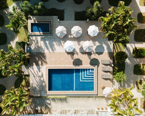 an overhead view of a swimming pool with chairs and trees at Pousada do Timoneiro in Arraial do Cabo