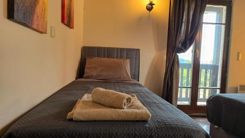 a bed with a towel on it with a window at Villa Palma Posidi with Private pool in Kalandra