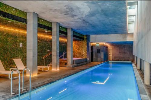 a large swimming pool in a room with a building at Luxury Docklands Loft 2B1B River view & Free parking in Melbourne
