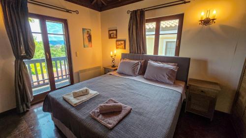 a bedroom with a bed with two towels on it at Villa Palma Posidi with Private pool in Kalandra