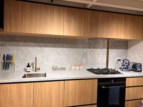 a kitchen with a sink and a stove top oven at Luxury Docklands Loft 2B1B River view & Free parking in Melbourne