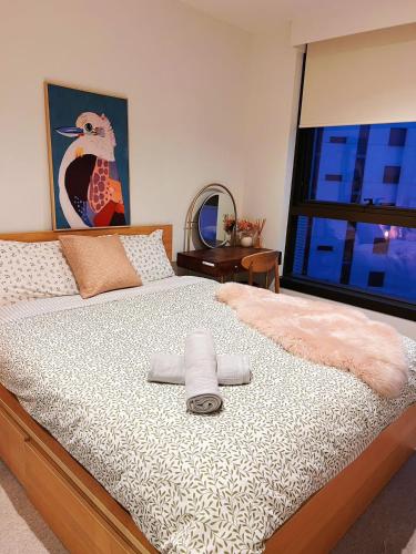 a bedroom with a bed with a large window at Luxury Docklands Loft 2B1B River view & Free parking in Melbourne