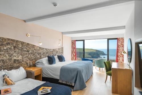 a hotel room with two beds and a view of the ocean at Bedruthan Hotel & Spa in Newquay