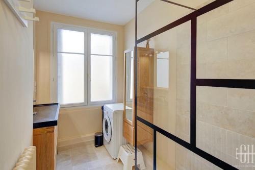 a bathroom with a washing machine and a window at L'oeillet - Place Plumereau in Tours