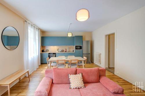 un salon avec un canapé rose et une table dans l'établissement L'oeillet - Place Plumereau, à Tours