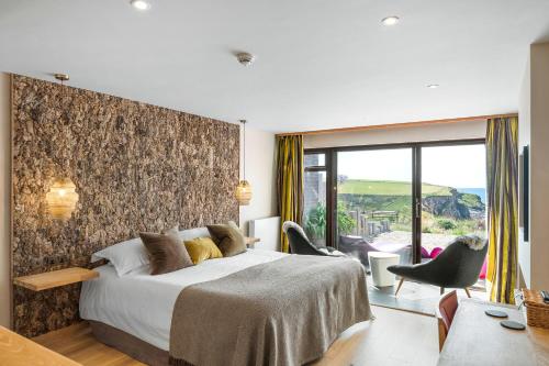 a hotel room with a bed and a large window at Bedruthan Hotel & Spa in Newquay