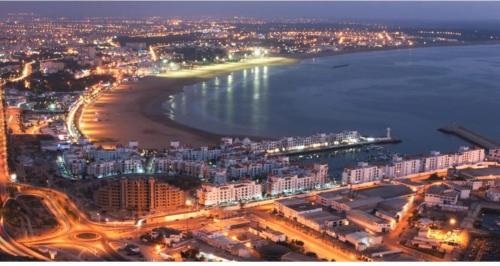 an aerial view of a city with a beach at night at Hôtel lhamra in Agadir