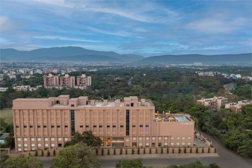 an aerial view of a building with mountains in the background at Vivanta Jamshedpur, Golmuri in Jamshedpur