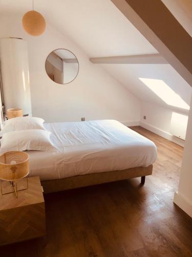 une chambre avec un grand lit et un miroir dans l'établissement Villa Les mûriers, à Saint-Hilaire-du-Rosier