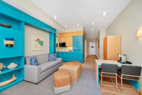 a living room with a couch and a table at Embassy Suites By Hilton Orlando Sunset Walk in Kissimmee