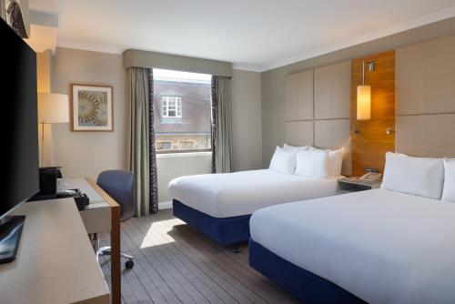 a hotel room with two beds and a window at Hilton Cambridge City Centre in Cambridge