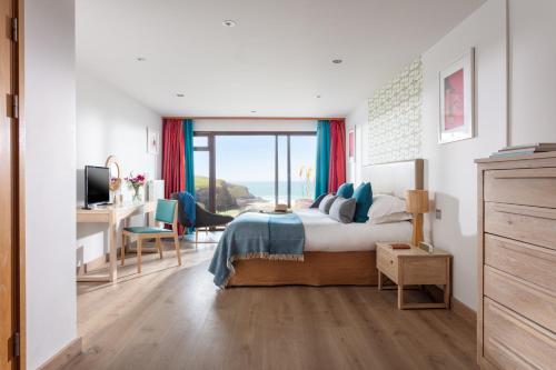 a bedroom with a bed and a desk with a computer at Bedruthan Hotel & Spa in Newquay