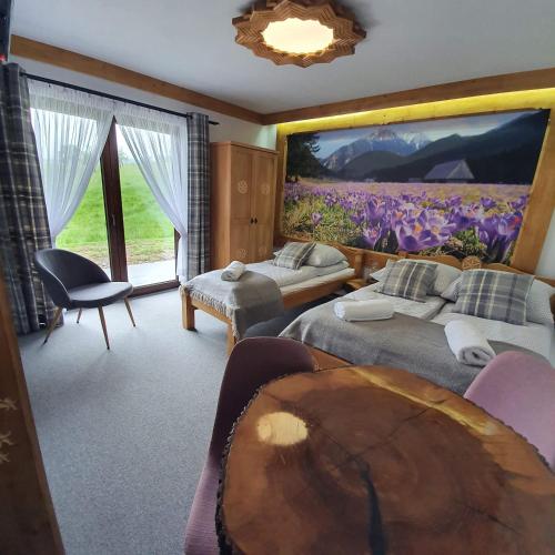 a bedroom with two beds and a large painting on the wall at Willa Kobiela in Witów