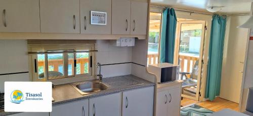 uma cozinha com um lavatório e uma bancada em Mobile home Viareggio - including airco- Camping Paradiso - G008 em Viareggio