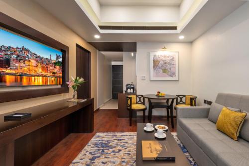 a living room with a couch and a tv at Vivanta Jamshedpur, Golmuri in Jamshedpur