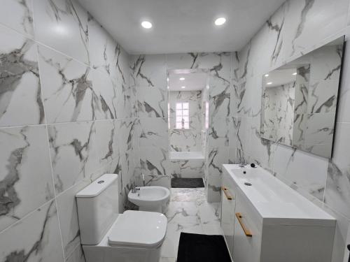 a white bathroom with a toilet and a sink at Villa de Lagos Coloridos in Los Montesinos