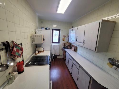 una cucina con armadietti bianchi e frigorifero bianco di Duplex con Vistas a la Ria a Miengo