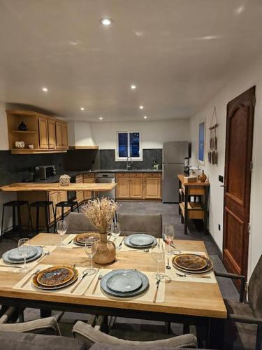 - une cuisine avec une table en bois, des assiettes et des verres à vin dans l'établissement Superbe bas de Villa au calme, à Cagnes-sur-Mer