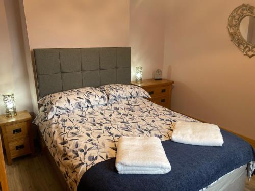 St matthews cottage في Aspatria: غرفة نوم عليها سرير وفوط