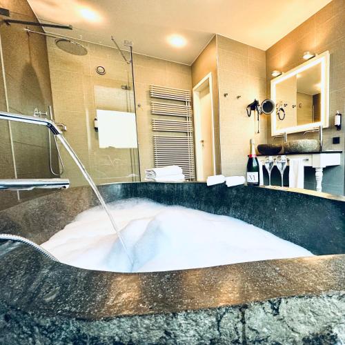 a bathroom with a tub with a water fountain at Le Clervaux Boutique Hotel & Spa in Clervaux