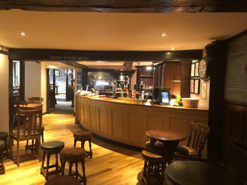 a bar in a restaurant with stools and a counter at White Hart, Andover by Marston's Inns in Andover