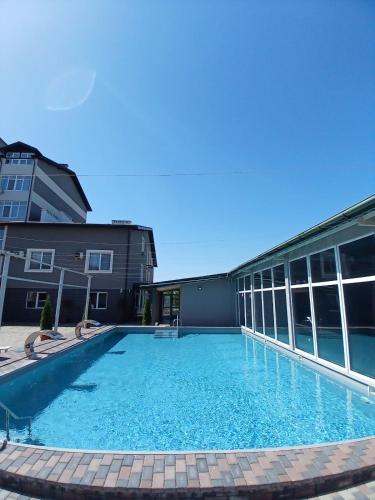 a large swimming pool with chairs and a building at Готель Гармонія. Термально-оздоровчий комплекс. in Uzhhorod