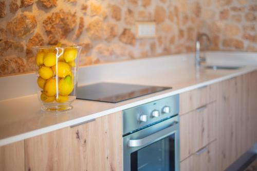 a vase filled with lemons on a counter in a kitchen at Can Pere Rapinya in Algaida