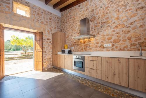 a kitchen with wooden cabinets and a large window at Can Pere Rapinya in Algaida