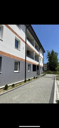 a large white building with a brick driveway at Apartmani borova 2 in Veliko Gradište