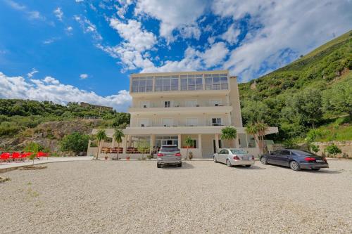 a building with two cars parked in a gravel parking lot at Seaview Bunec in Piqeras