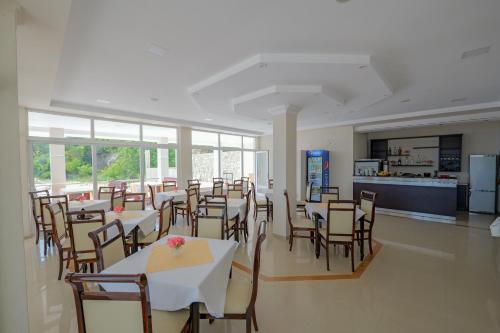a restaurant with tables and chairs and a kitchen at Seaview Bunec in Piqeras
