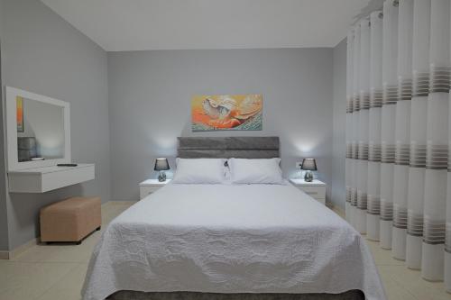 a bedroom with a white bed and two night stands at Seaview Bunec in Piqeras
