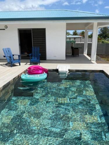 a swimming pool with twoogie boards and a house at Bungalow Sweet escape in Fare