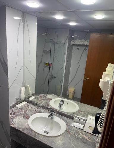 a bathroom with two sinks and a large mirror at El Sheikh Suites Hotel in Beirut