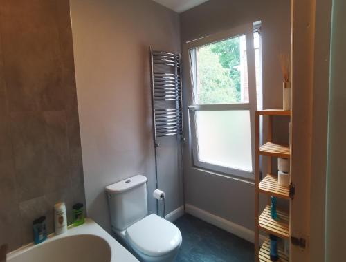 uma casa de banho com um WC, um lavatório e uma janela em Large nice double room to rent in a modern quiet flat close to train station and bus stop em Enfield
