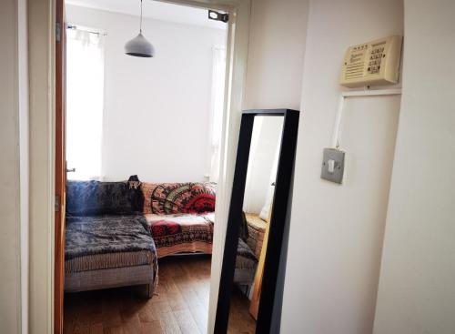 um espelho em frente a uma sala de estar com um sofá em Large nice double room to rent in a modern quiet flat close to train station and bus stop em Enfield