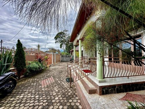 a house with a porch and a driveway at Inshuti Home Stay in Gasanze